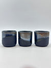 Three black stoneware mugs with a bronze glaze